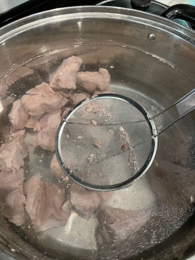 sieving bun rieu pork bone broth